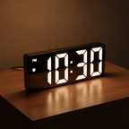 Digital alarm clock on a warm wooden nightstand at night showing the time in large white digits