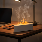 Flame-effect diffuser on a work desk beside a laptop, notebook, and pen during a focus session