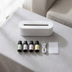 What comes in the box: the diffuser switched off with four amber bottles of essential oil, a USB-C cable and a leaflet