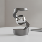 Gunmetal kinetic magnetic levitator with a mirror-polished ball floating in its S-curve base