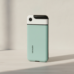 Mint phone lock box standing closed on a pale oak desk in soft daylight