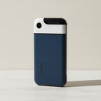 Navy blue phone lock box standing closed on a pale oak desk