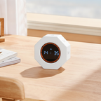 Octagonal pomodoro timer on a minimal desk with its display showing an active countdown in daylight